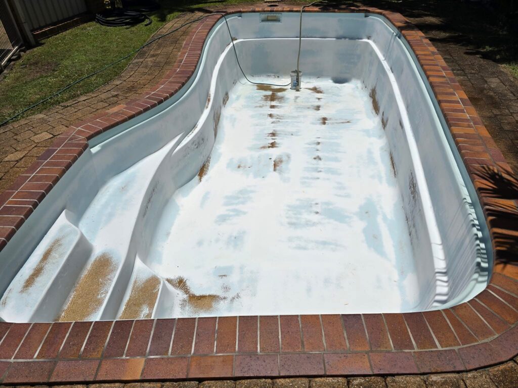 Fibreglass pool with severe rust stains and damage Gold Coast before professional resurfacing repair treatment